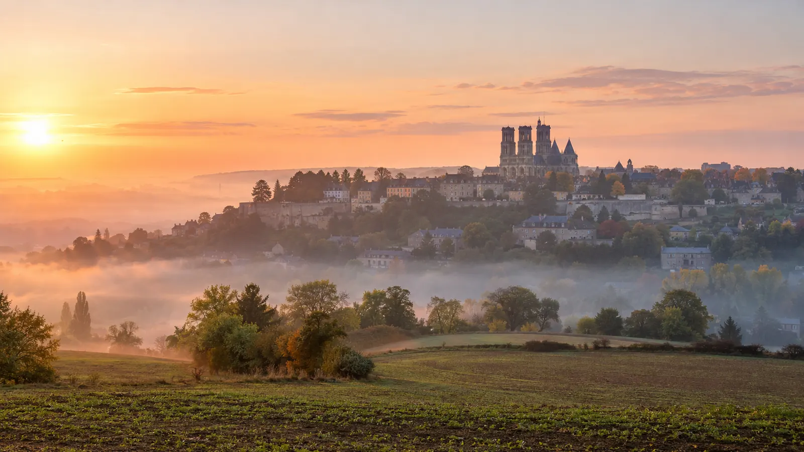 Ville haute de Laon perchée sur sa butte avec la cathédrale dominant les champs au lever du jour