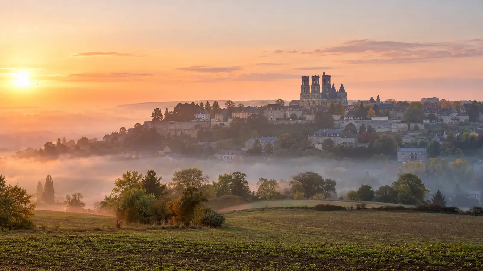 Ville haute de Laon perchée sur sa butte avec la cathédrale dominant les champs au lever du jour